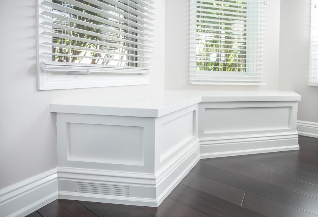 Dining nook with a built-in window seat and wainscoting