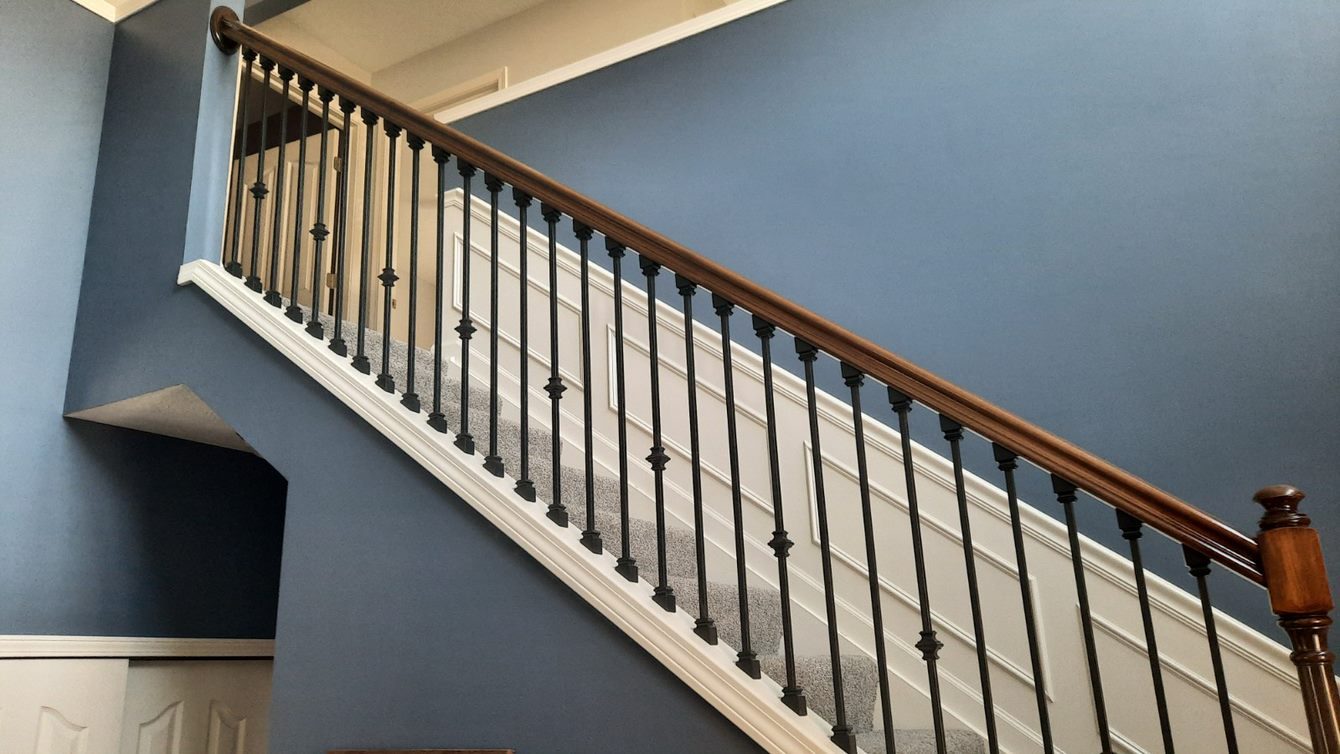 Staircase remodel with a navy accent wall and wood-and-metal railing