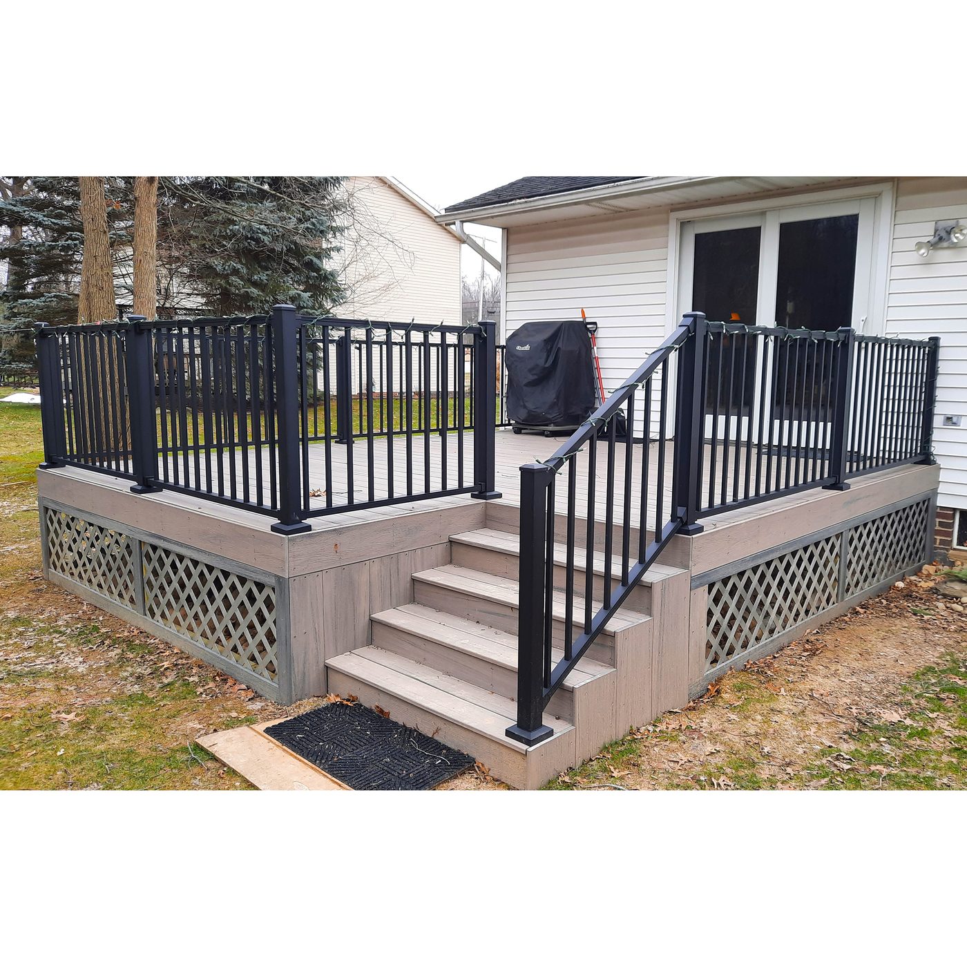 New backyard deck with black metal railing and staircase
