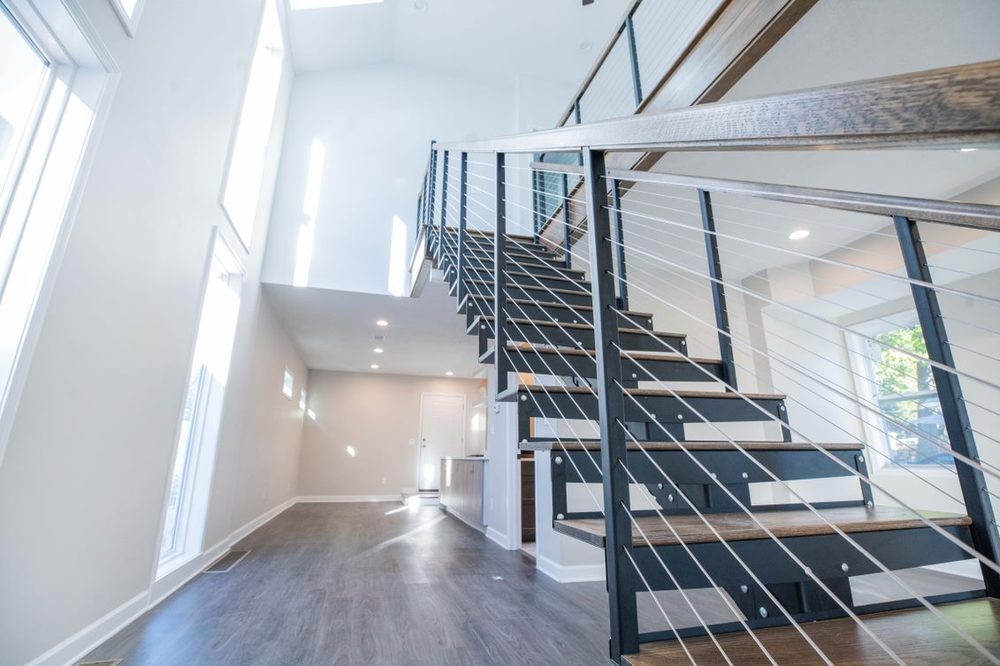 Open loft remodel with tall windows and cable stair railing