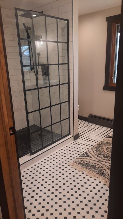 Bathroom remodel with a black-framed glass shower door and checkerboard tile floor