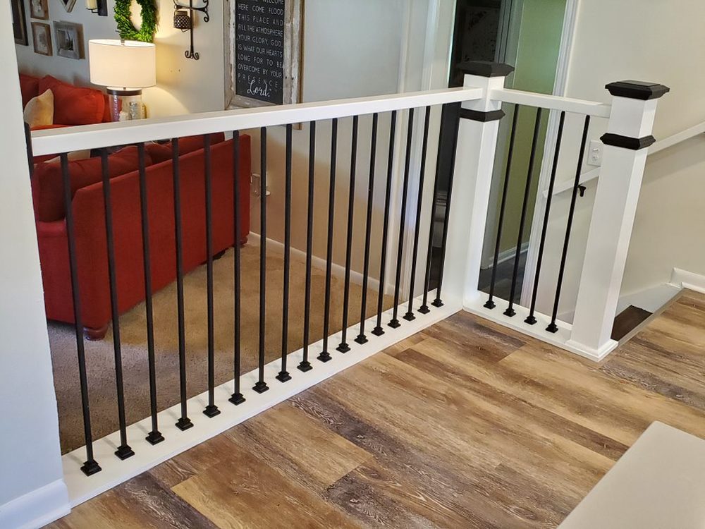 Stairwell remodel with a dark accent wall and wood balusters
